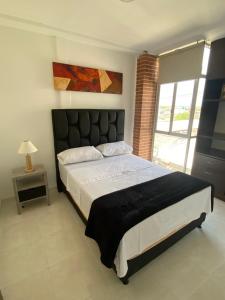 a bedroom with a large bed and a window at Acogedor Apartaestudio in Pitalito