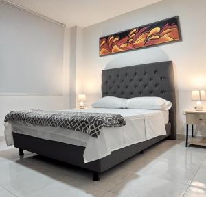 a bedroom with a large bed with a black headboard at Acogedor Apartaestudio in Pitalito