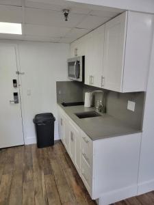 a kitchen with white cabinets and a sink and a microwave at 3407 Luxury option for your visit in Orlando