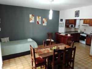 a room with a table and a bed and a kitchen at Complejo Semaso in Santa Rosa