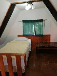 a bedroom with a bed and a table in a attic at Cabañas casa victoria in Centro Jaramillo