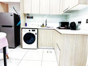 eine Küche mit einer Waschmaschine und einem Kühlschrank in der Unterkunft Green Heaven by GreatDay in Masai