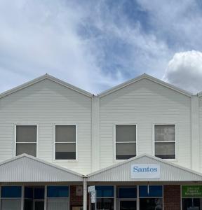 a white building with a santos sign on it at Stays on Main in Narrabri