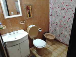 a bathroom with a toilet and a sink at Complejo Semaso in Santa Rosa