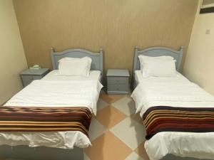 two beds sitting next to each other in a room at نزيل للشقق المفروشة in Taif