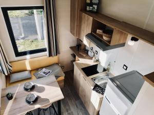 a tiny kitchen with a table and a sink at Mobil-Home Jullouville, 2 pièces, 2 personnes - FR-1-361A-24 in Jullouville-les-Pins