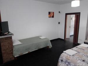 a room with two beds and a television in it at Complejo Semaso in Santa Rosa