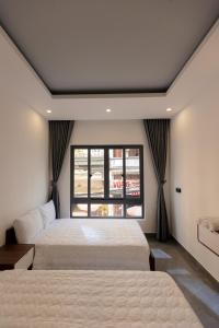 een slaapkamer met 2 bedden en een raam bij Cassie Boutique Hotel in Vung Tau