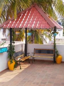 due panche sedute sotto un gazebo su un patio di Rani Homestay Khajuraho a Khajurāho