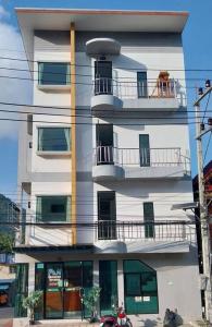 a tall white building with a balcony on it at Ava 2 Budget Hotel Koh Tao in Koh Tao