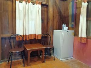 a kitchen with a table and two chairs and a refrigerator at The Aerie in Pang Mapha