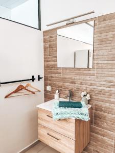 ein Bad mit einem Waschbecken und einem Spiegel in der Unterkunft Vaikea Fare in Mahina