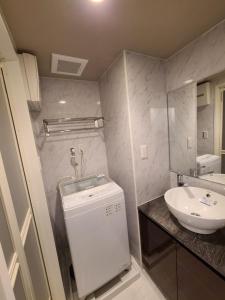 a bathroom with a sink and a washing machine at パーリーフラッツ品川高輪台 PEARLY FLATS Shinagawa Takanawadai in Tokyo