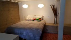 een slaapkamer met een bed met een kussen en 2 verlichting bij Modern lofty studio in Midtown / Charming Old SW in Reno