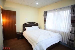 a bedroom with a large bed and a window at Hotel Melungtse & Apartment in Tokna