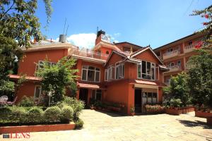 a large red brick house with a courtyard at Hotel Melungtse & Apartment in Tokna
