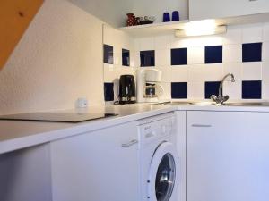 une cuisine blanche avec un lave-linge. dans l'établissement Maison Gruissan, 2 pièces, 6 personnes - FR-1-229-839, à Gruissan
