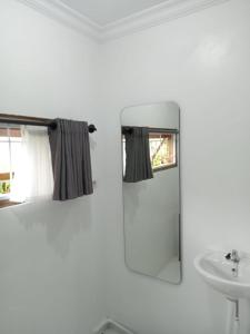 a white bathroom with a sink and a mirror at Guest House d Valeri in Labuan Bajo