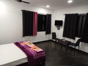 イドゥッキにあるLa casa de Alexa homestayのベッドルーム1室(ベッド1台、椅子2脚、テレビ付)