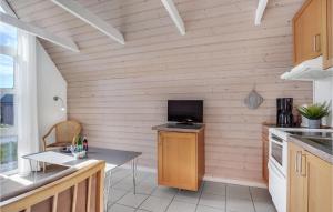 a kitchen with a table and a tv on a wall at Stunning Home In Hadsund With Kitchen in Hadsund +10 photos