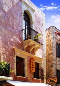 a building with a balcony with a dog on it at Caza Latina in Chania