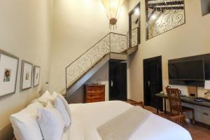 um quarto com uma cama branca e uma escada em The Riverside Inn em Boquete