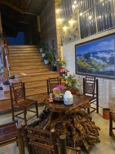 a room with a table and chairs and a staircase at Bac Son Homestay in Bắc Sơn