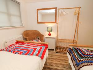 1 Schlafzimmer mit 2 Betten, einer Lampe und einem Spiegel in der Unterkunft Skiber Goth in Menheniot