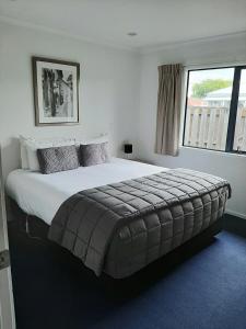 ein großes Bett in einem Schlafzimmer mit Fenster in der Unterkunft Claremonte Motor Lodge in Hastings