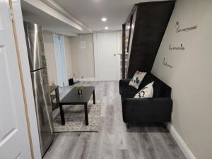Comfy Private Unit في تورونتو: غرفة معيشة مع أريكة سوداء وطاولة