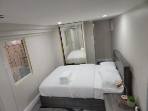 Dormitorio pequeño con cama y espejo en Comfy Private Unit, en Toronto