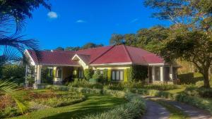 una casa gialla con tetto rosso e vialetto di The Riverside Inn a Boquete