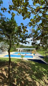 HTL campestre aguas vivas في Doradal: شجرة امام مبنى به مسبح