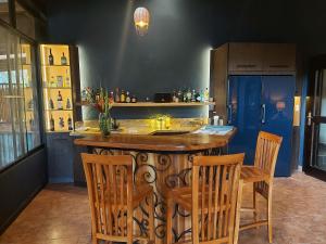 a kitchen with a bar with chairs and a table at The Riverside Inn in Boquete