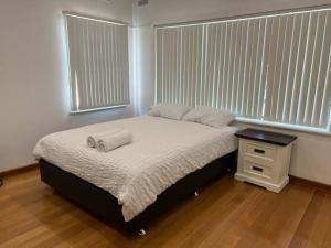 a bedroom with a bed and a window with blinds at St Albans Alexina 1 - Near Shopping in St Albans