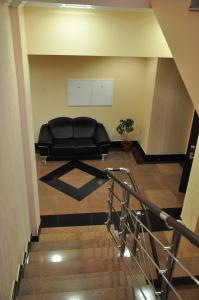 a waiting room with a black couch in a building at Dvorik Hotel in Krasnoyarsk