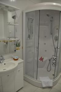 a white bathroom with a shower and a sink at Dvorik Hotel in Krasnoyarsk