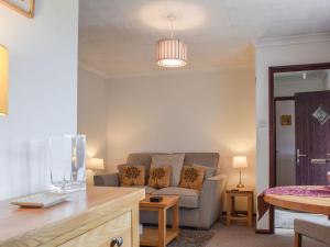 a living room with a couch and a table at Magnolia Cottage in Ratley