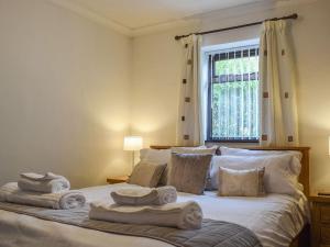 1 dormitorio con 1 cama con toallas en Magnolia Cottage, en Ratley
