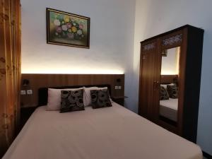 a bedroom with a large bed with a mirror at Villa Asri in Batu