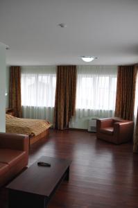 a hotel room with a bed and a couch and a table at Dvorik Hotel in Krasnoyarsk