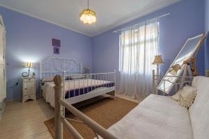 a blue bedroom with two beds and a window at Villa Ivano apartmani in Biograd na Moru