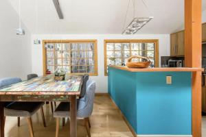 una cocina con una mesa de madera y una isla azul en Sur Grove Big Sur, en Big Sur