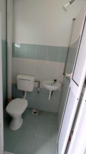 La salle de bains est pourvue de toilettes et d'un lavabo. dans l'établissement Pusing Holiday Apartment, à Pusing