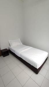 a bed sitting on a tiled floor in a bedroom at Pusing Holiday Apartment in Pusing