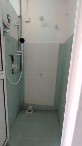 La salle de bains est pourvue d'une douche et de carrelage vert. dans l'établissement Pusing Holiday Apartment, à Pusing