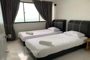 two beds in a room with a window at Happy Home 26 Sri Sayang Batu Ferringhi in Batu Ferringhi