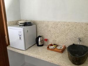 eine Küchentheke mit Mikrowelle und Kühlschrank in der Unterkunft Villa iris Homestay in Uluwatu