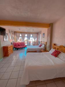 a large bedroom with two beds and a couch at Hotel Carnaval in Huejotzingo