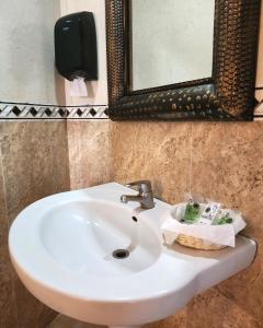 a white sink in a bathroom with a mirror at Motel Atenas in Puebla